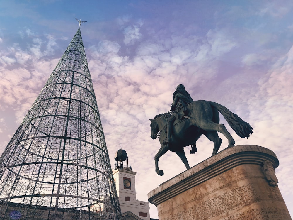 man riding on horse statue near building