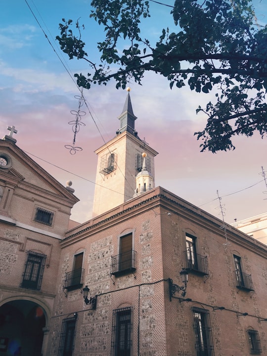 low-angle photo of concrete building under pinkish sky in Church of San Ginés Spain