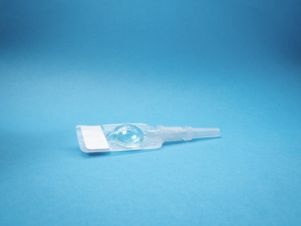 white plastic tube on blue surface