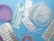 Various contraceptive methods are displayed including birth control pills in blister packs, a diaphragm, a female condom, an intrauterine device (IUD), and an implant. The background is a solid light blue surface.