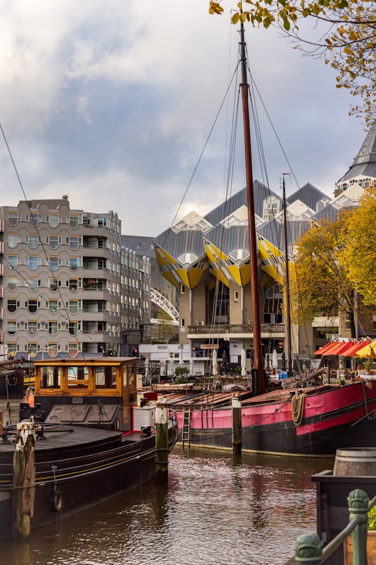 different boats on body of water near high-rise buildings under white and blue sky in Cube Houses Netherlands