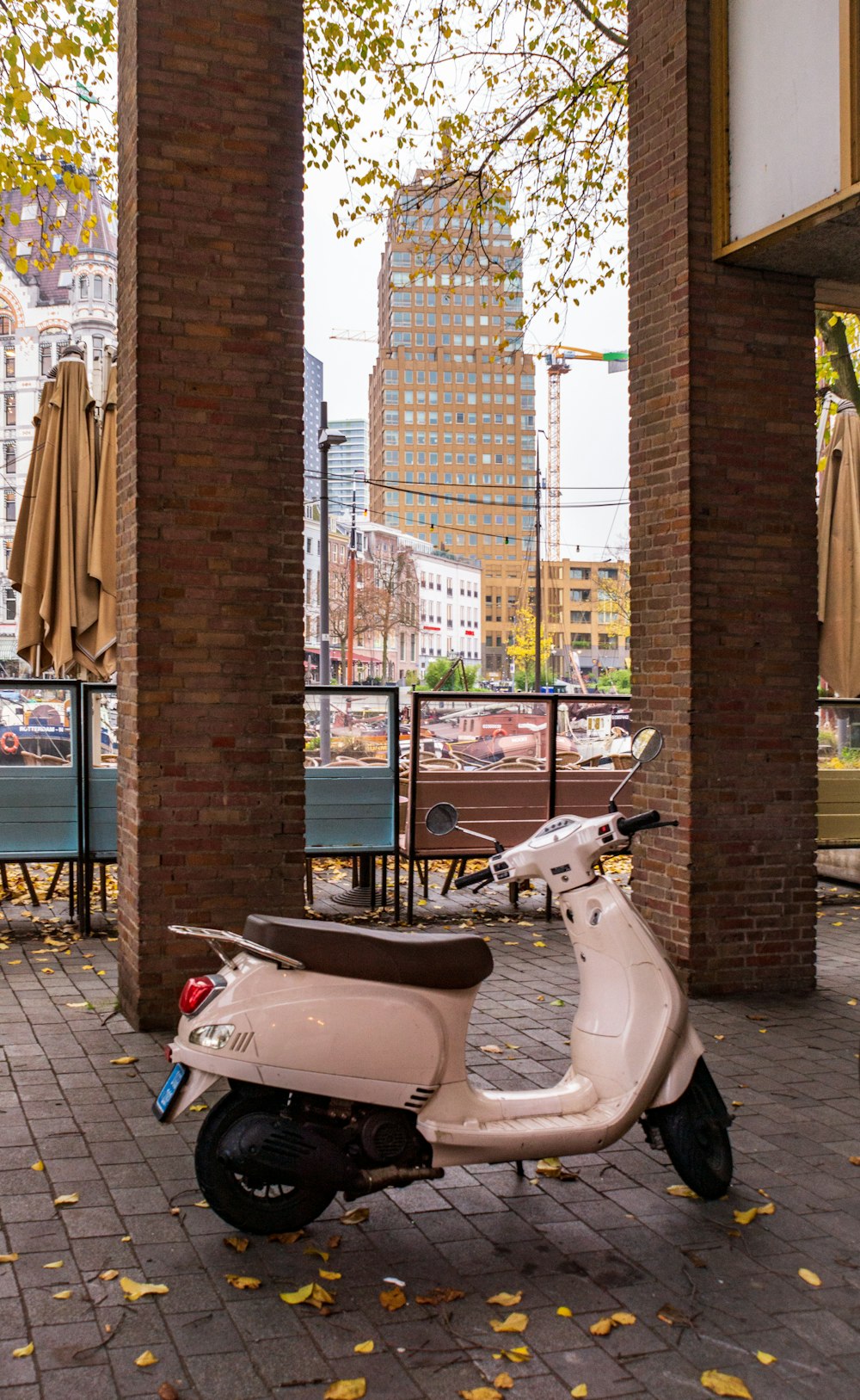 white motor scooter parked near pillars