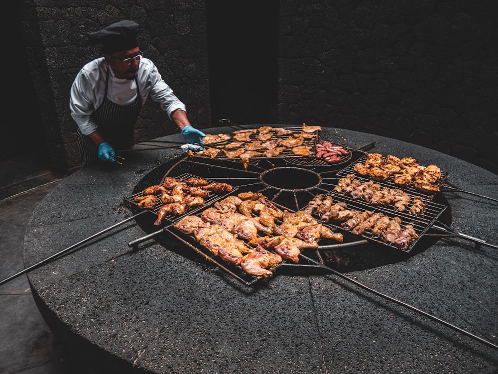 male chef standing while roasting chicken