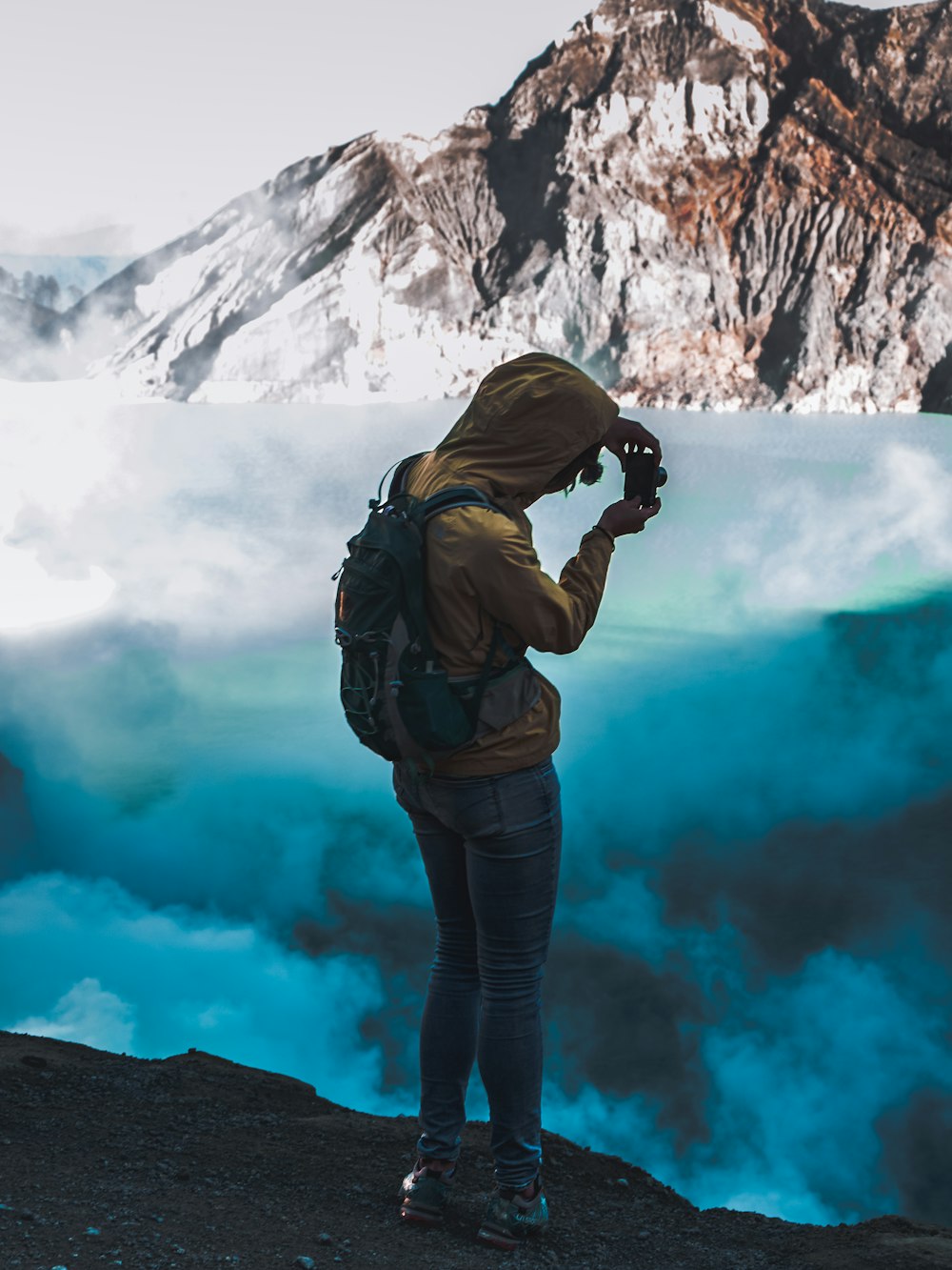 man taking picture of a blue sea of clouds