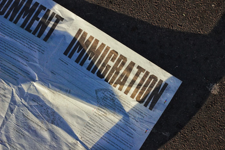 Crumpled newspaper displaying 'IMMIGRATION' in bold, reflecting immigration policy discussions