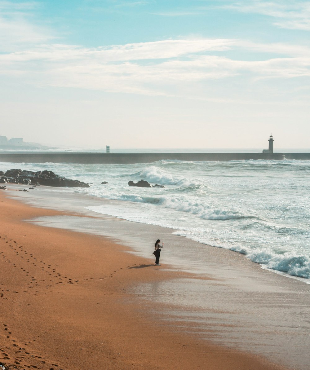 woman standing on shore during daytime