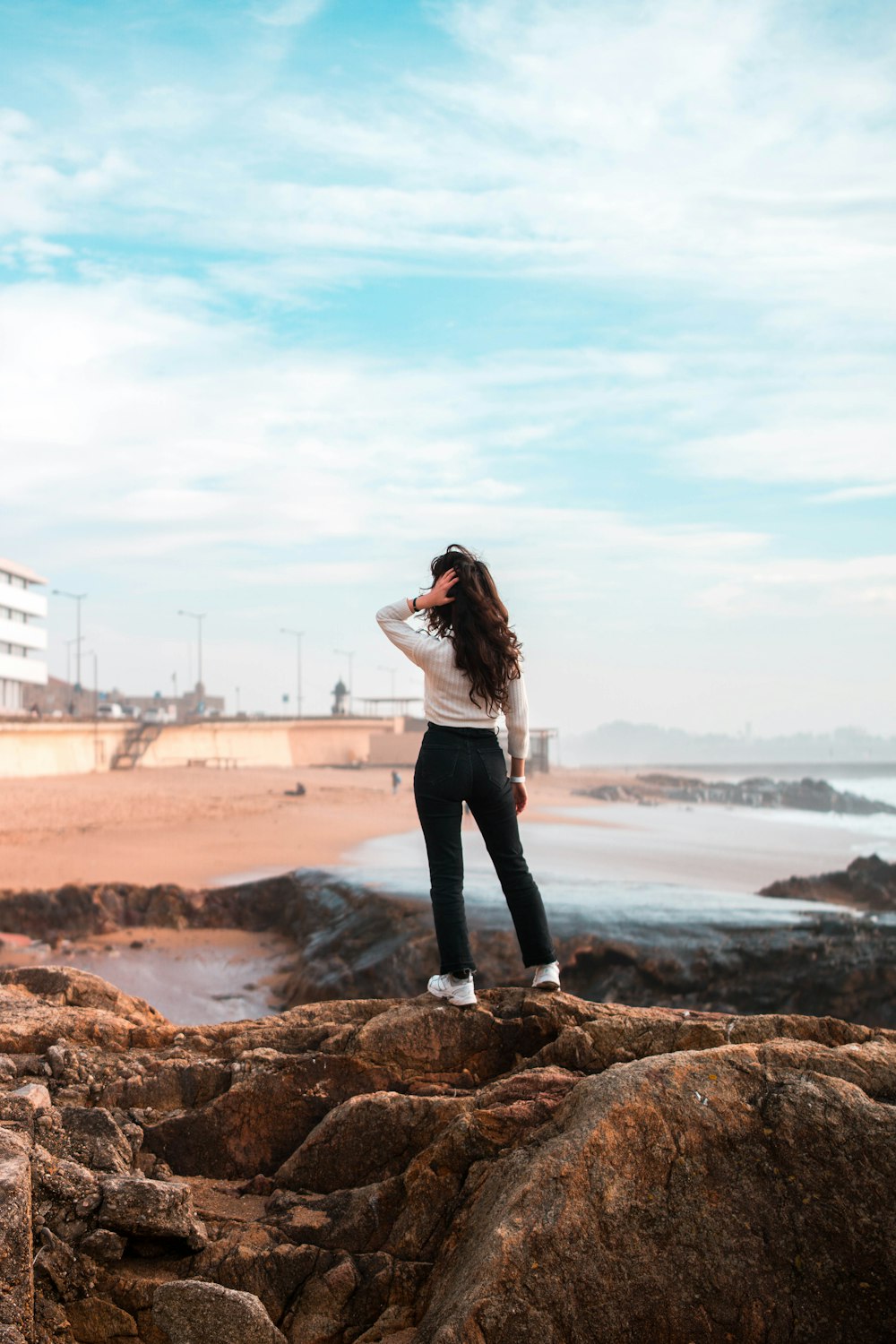 woman standing on rock formation near outdoor during daytime