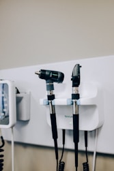 2 othoscopes sitting on top a wall