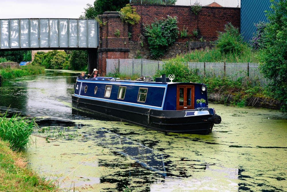 blue boat on river near bridge