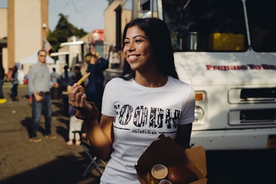 A smiling customer holding a ticket while enjoying fries at a lively local restaurant during the contest.