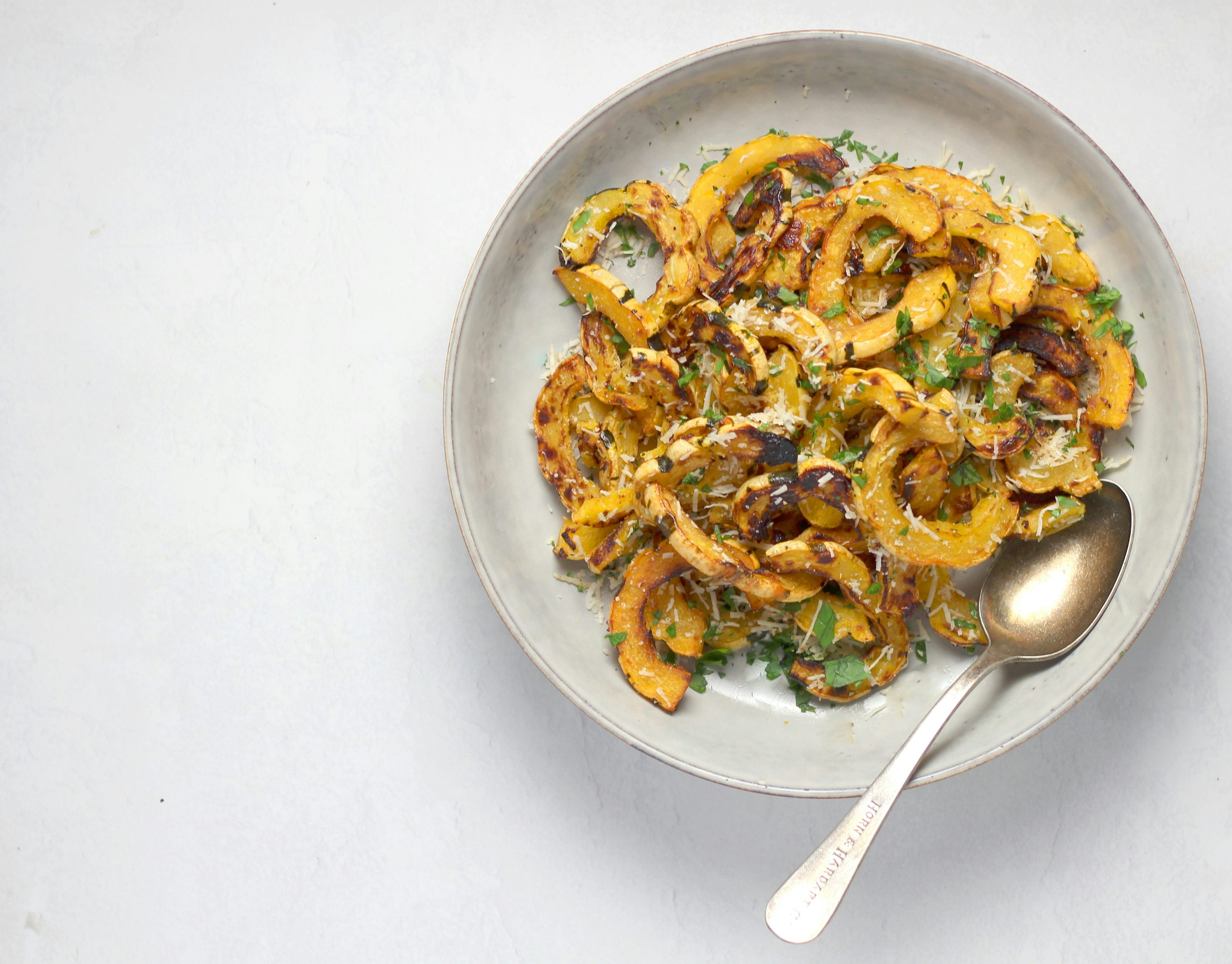 delicata squash sliced and in a ceramic bowl