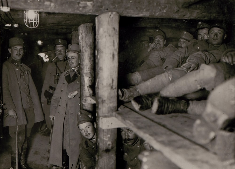 fotografia in scala di grigi di uomini soldato all'interno della grotta