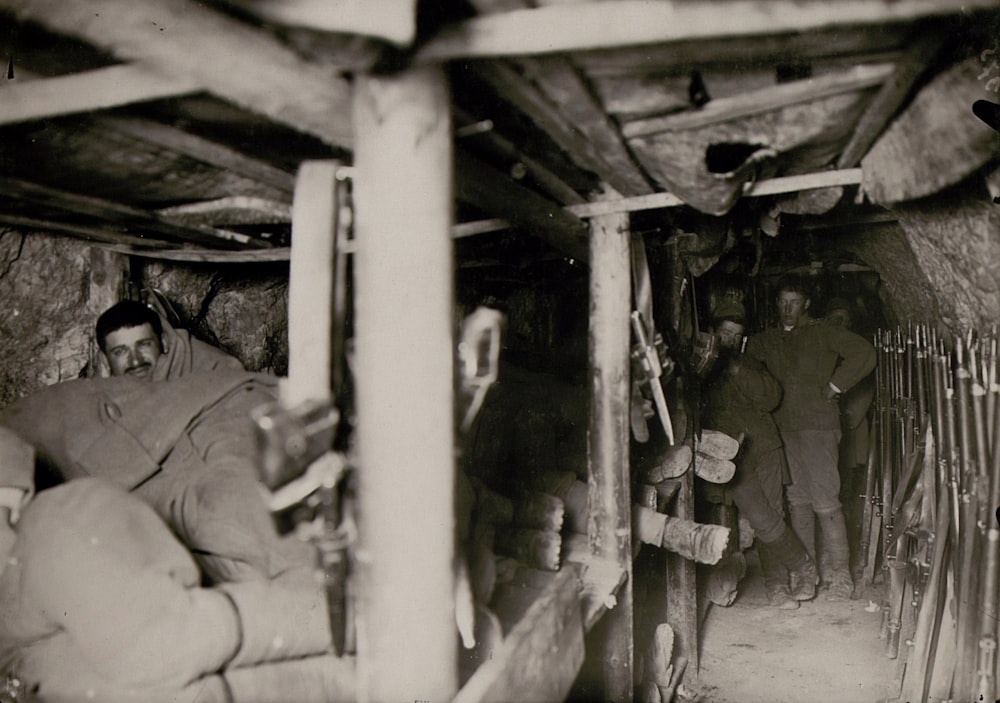 Fotografía en escala de grises de hombres dentro de una cueva