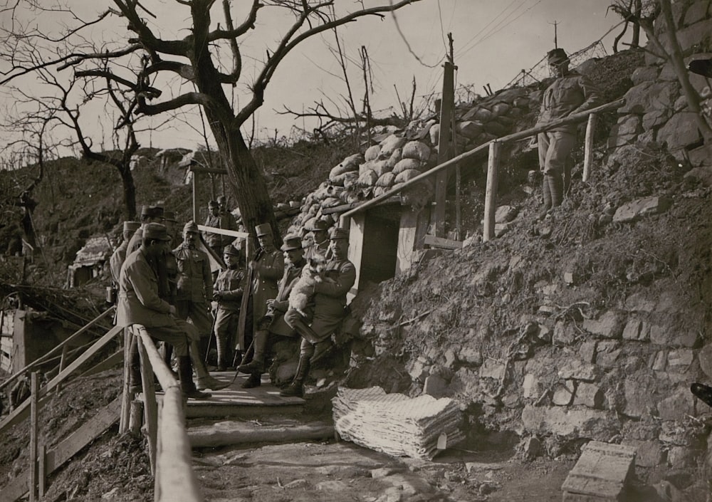 grayscale photography of soldiers outside cave