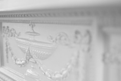 A close-up of a finely crafted veneered panel with artistic painted details.