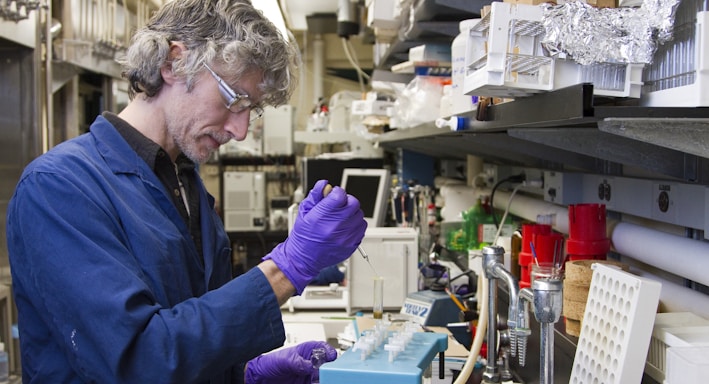 woman dropping a specimen on a test tube