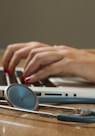 person sitting while using laptop computer and green stethoscope near