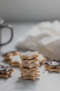 Close-up photo of beautifully decorated sugar cookies with intricate pastel designs on a wooden table.