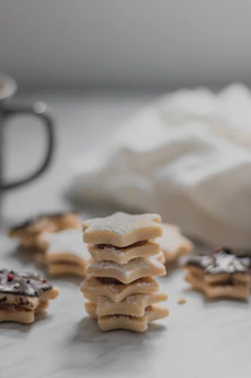 Close-up photo of beautifully decorated sugar cookies with intricate pastel designs on a wooden table.