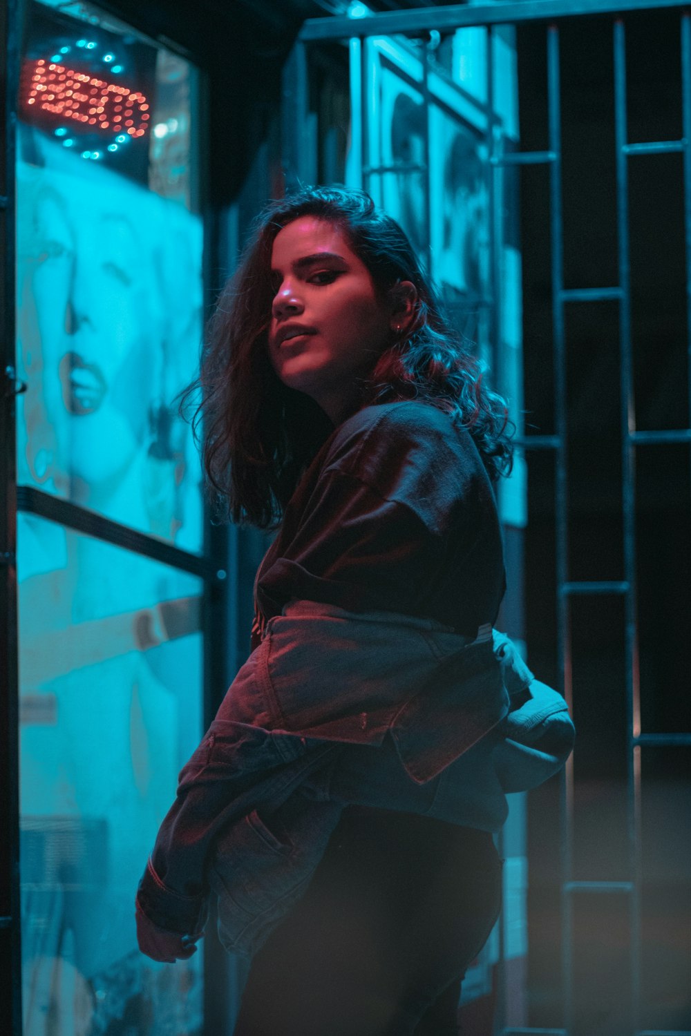 woman wears blue denim jacket near glass door