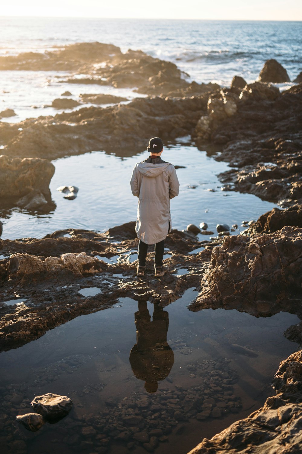 unknown person standing near body of water