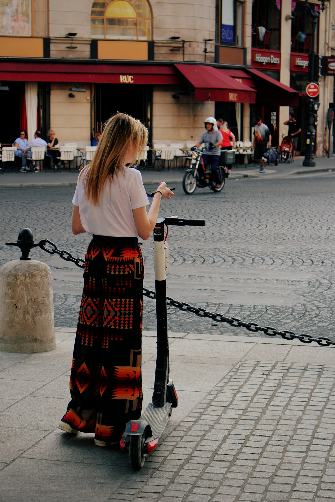 woman standing beside black and white kick scooter