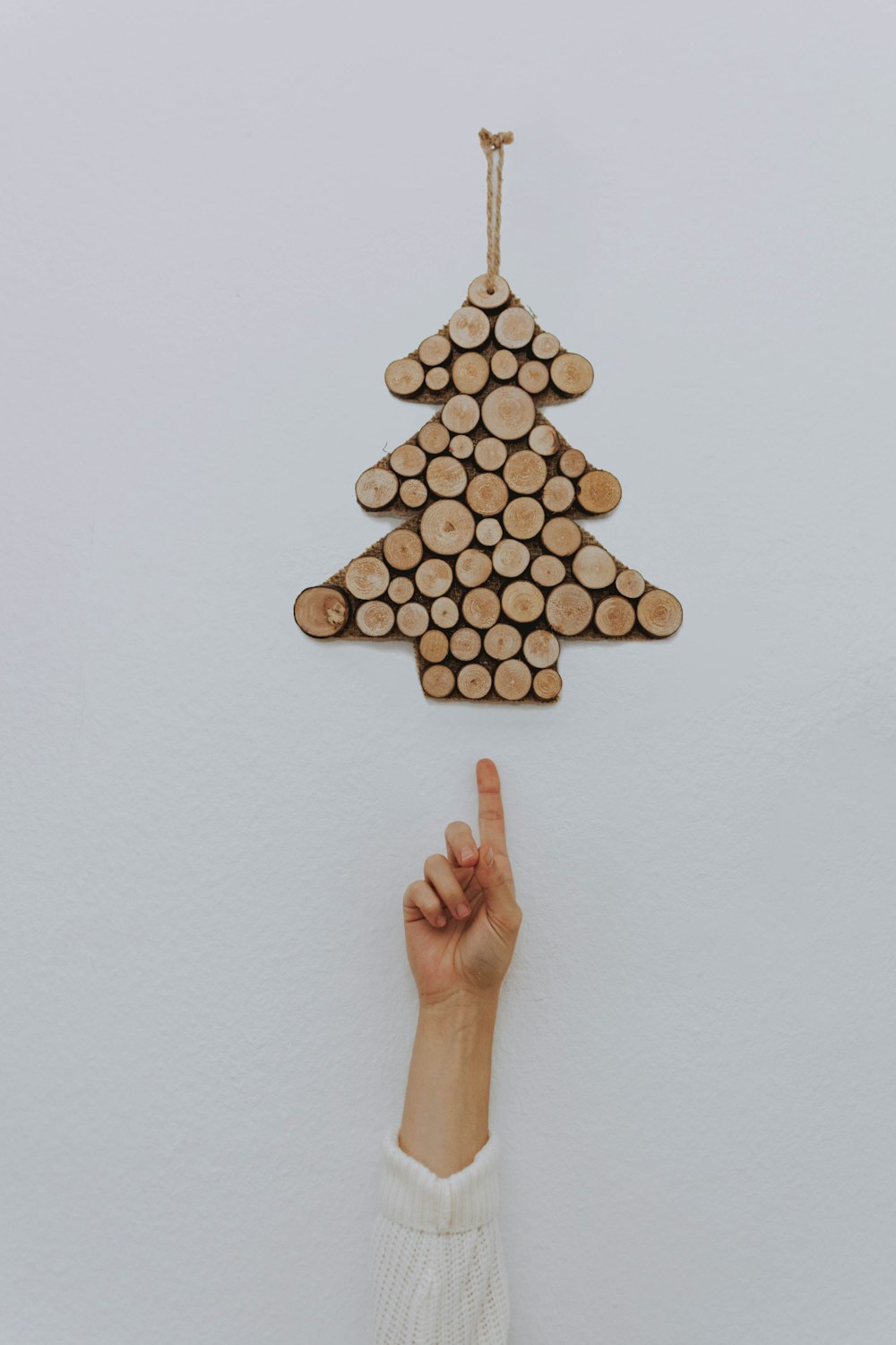 person pointing at brown hanging Christmas tree decor