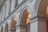 A series of elegant, classical arches are seen, each supported by robust columns. The architecture is ornate and detailed, featuring decorative moldings and clean lines that suggest a historical or formal building. Soft lighting illuminates the arches, creating gentle shadows and highlighting the structure's symmetry.