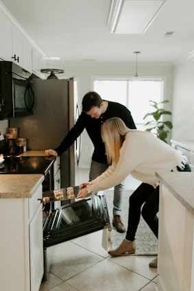 A skilled handyman carefully installing new kitchen cabinets in a bright, cozy home.
