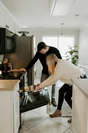 Technicians carefully installing a new refrigerator inside a cozy kitchen.