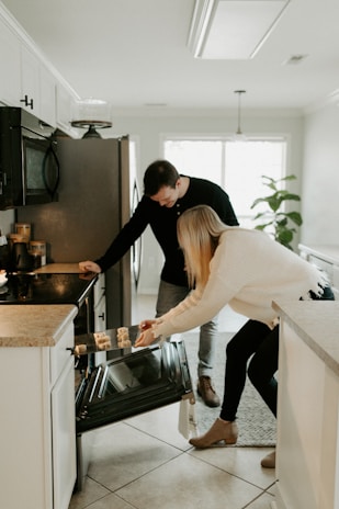 A family happily watching as their oven is being serviced by a friendly Lex Appliance Care technician.