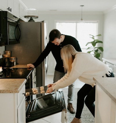 man and woman by open range oven