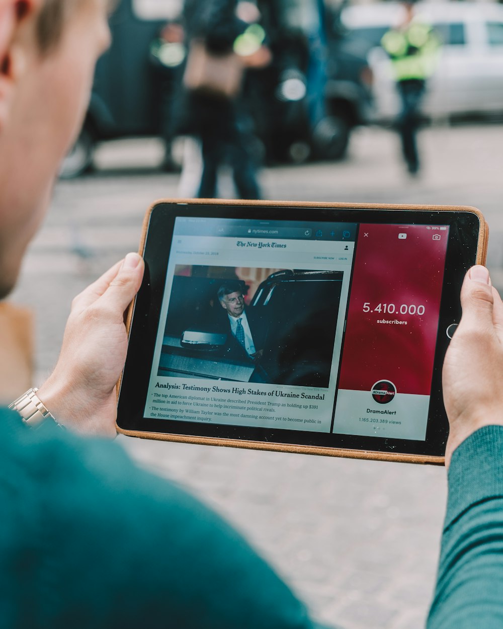 man wearing green long-sleeved shirt using iPad