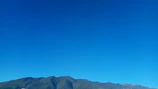 A peaceful view of the Atlas Mountains under a clear blue sky.