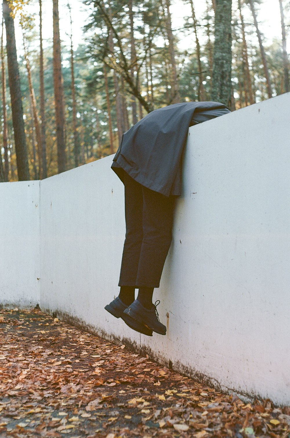 person leaning on white concrete fence