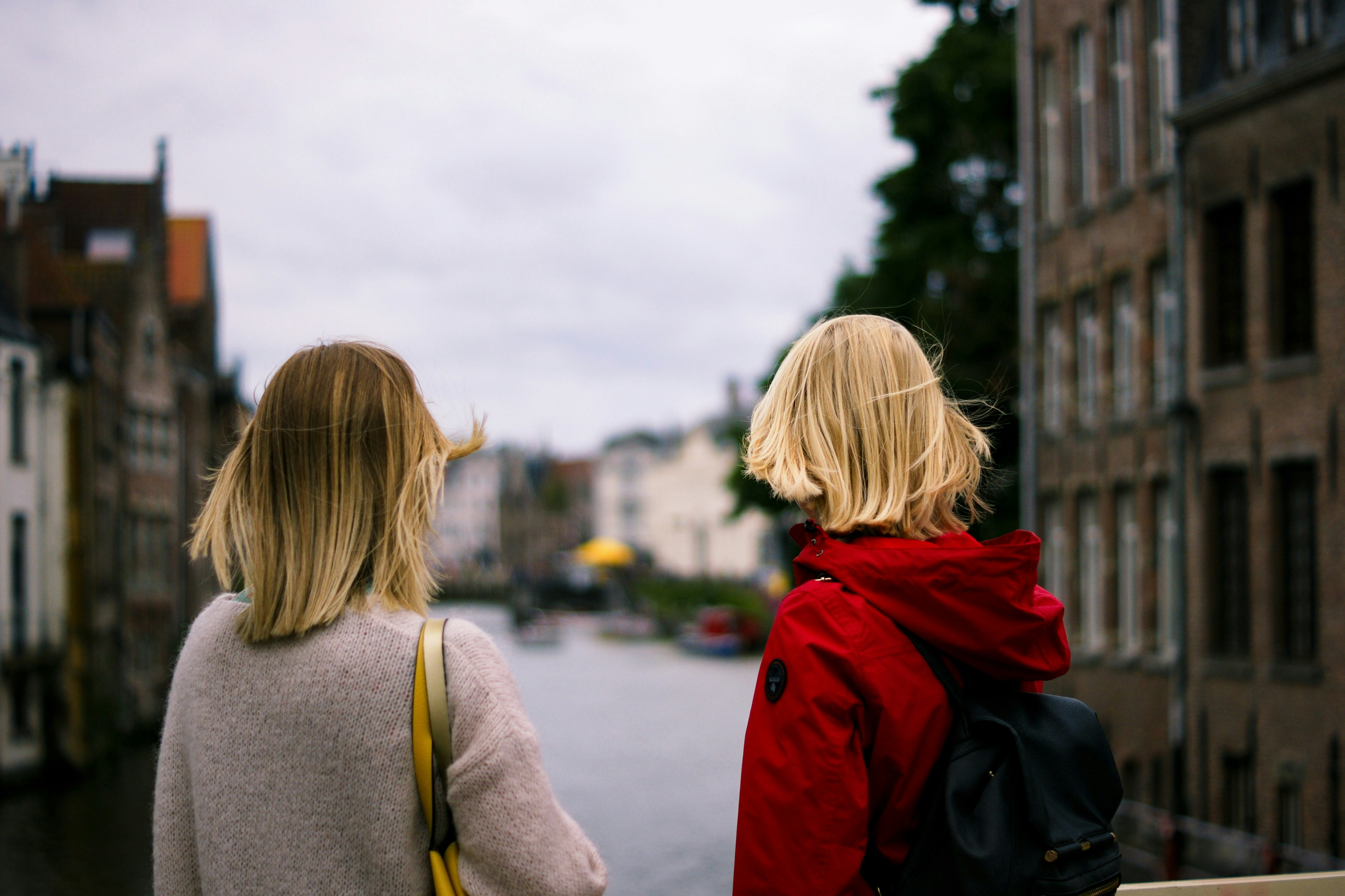 due donne in maglione grigio e giacca rossa con cappuccio