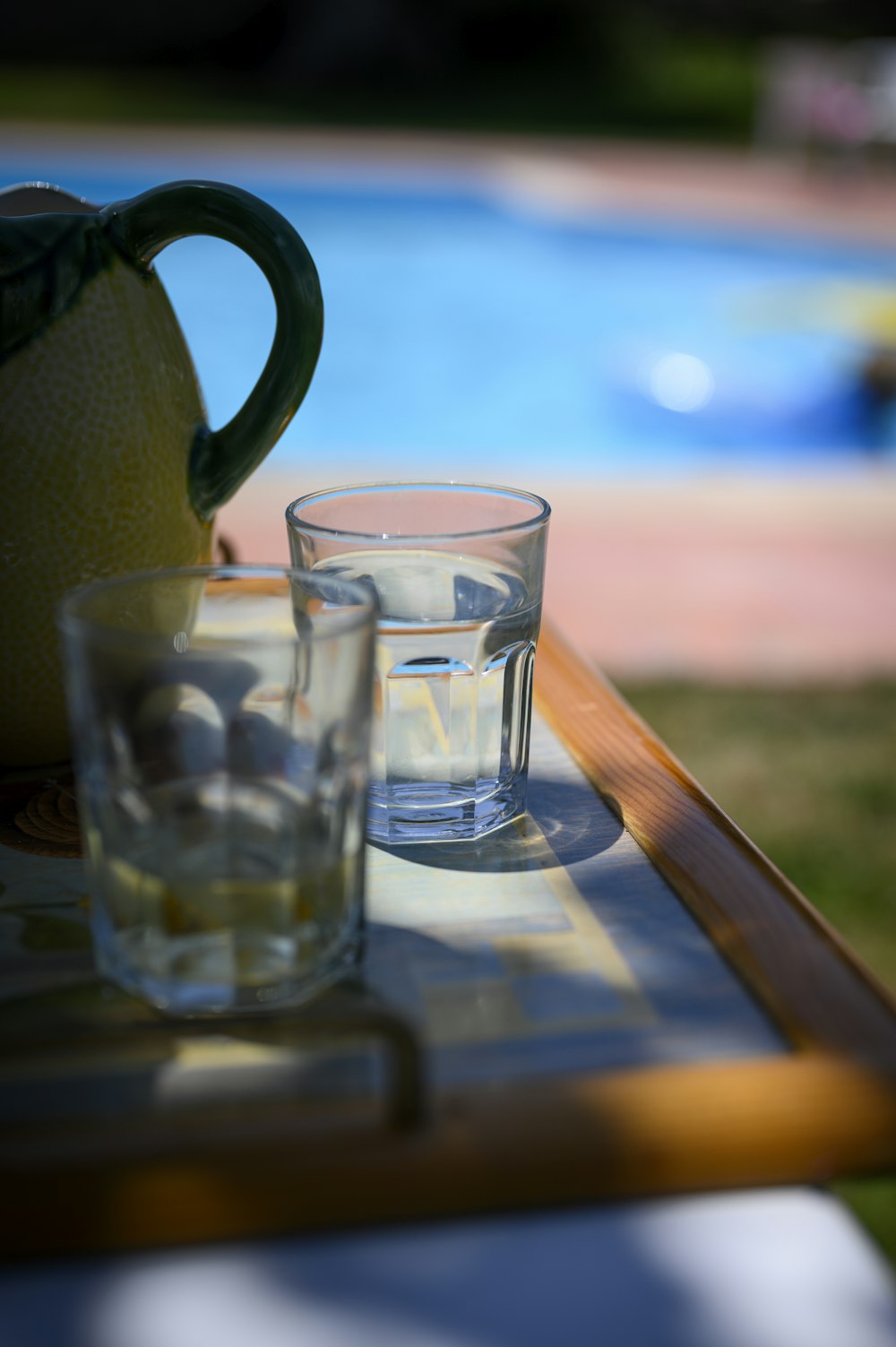 clear drinking glasses beside pitcher