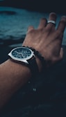 round silver-colored chronograph watch with black strap