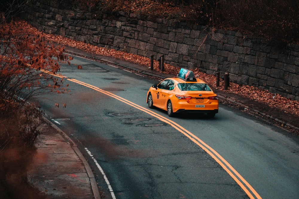 yellow sedan on road