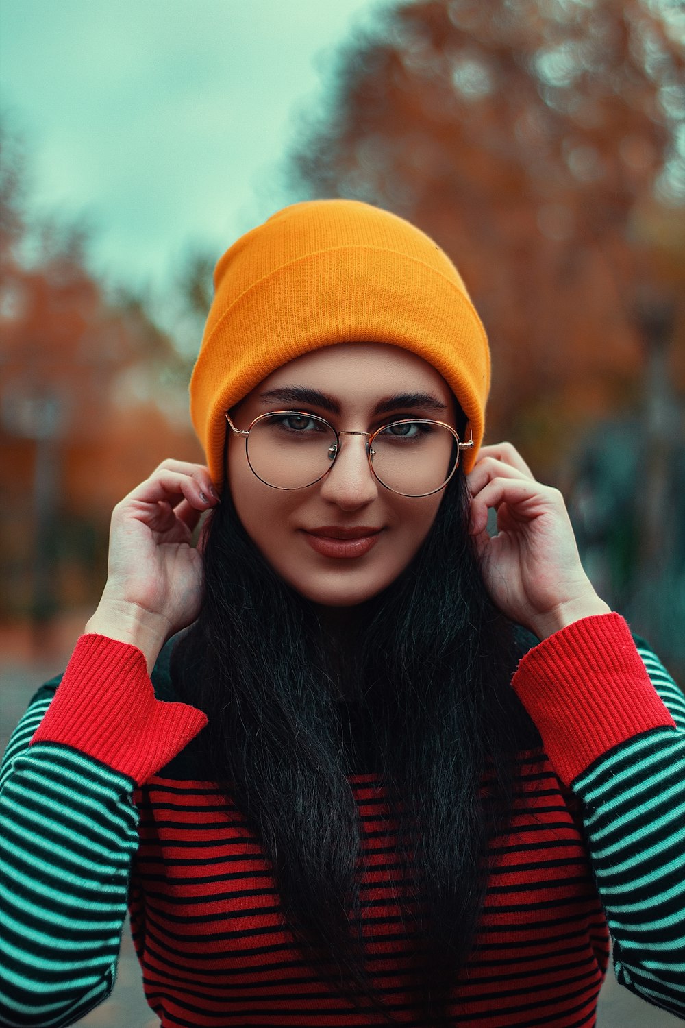 woman in silver eyeglasses and orange beanie cap in macro photography