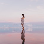 pregnant woman standing on calm body of water