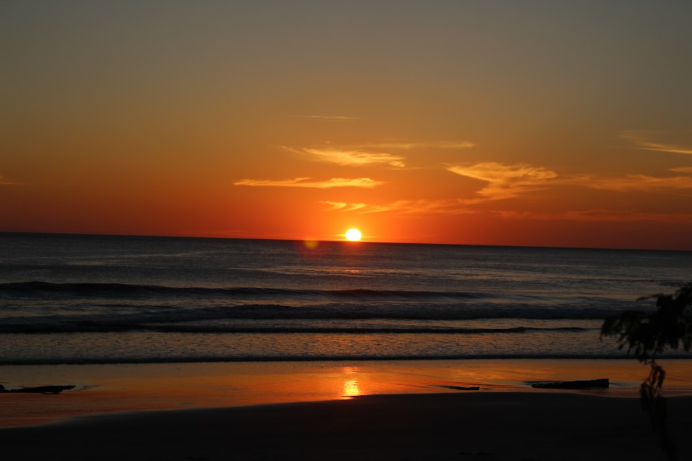 rippling body of water on the shore under golden hour