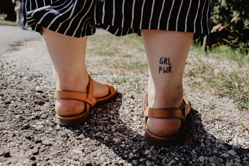 person wearing brown leather slide sandals