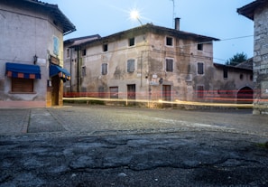 A rustic village street with a designated delivery point visible in the background.