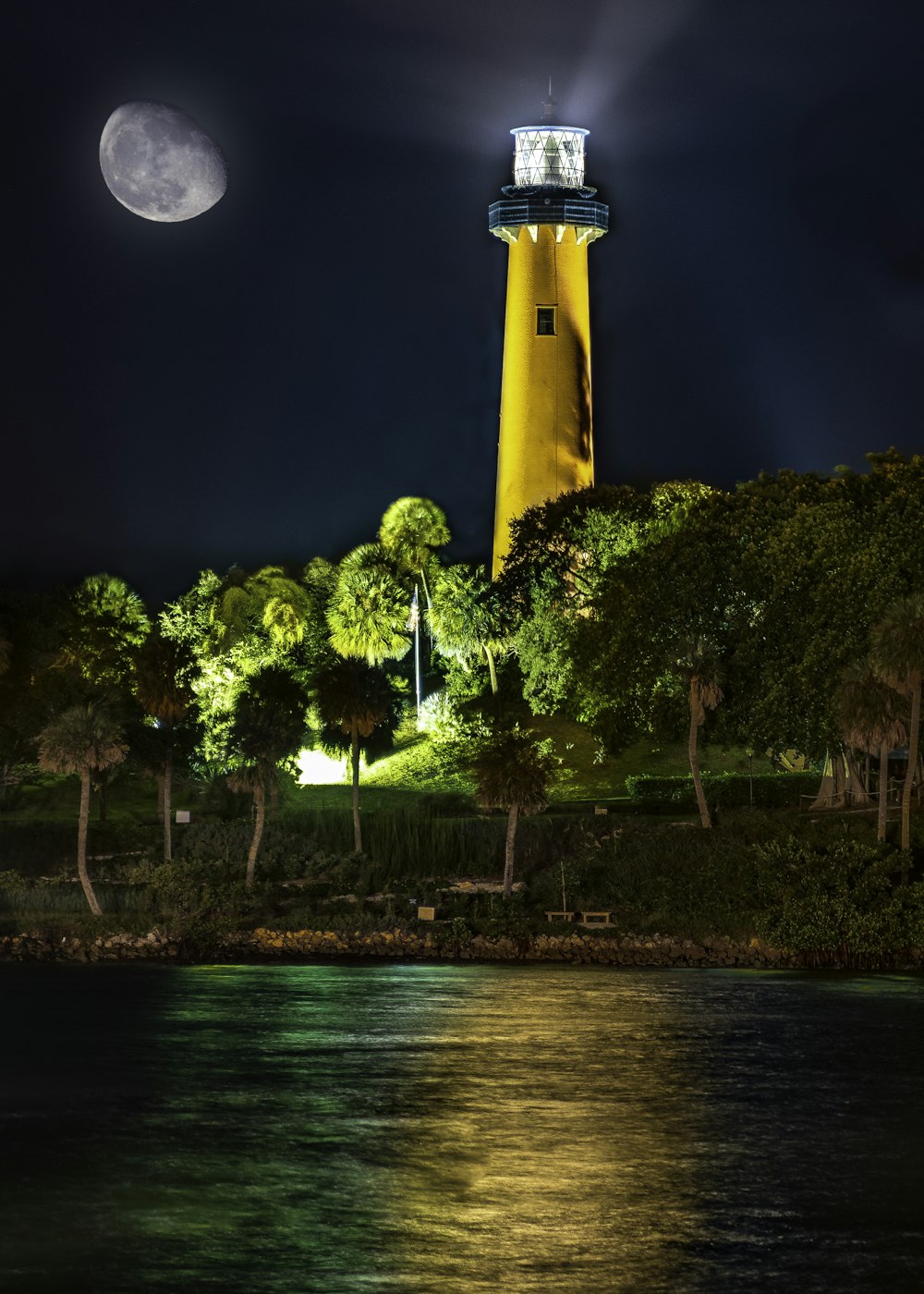 yellow and blue lighthouse beside body of water