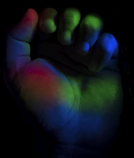 Close-up of colorful aura energy radiating from a person's hands.