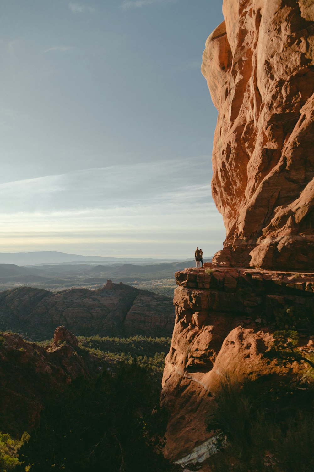 man and woman standing on mountain cliff during daytime