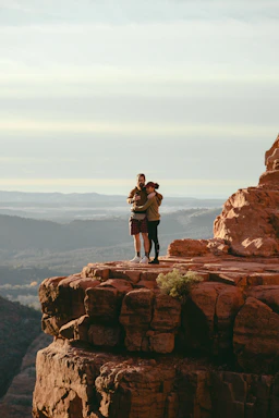 A warm handshake between two business professionals against a backdrop of red sandstone cliffs.