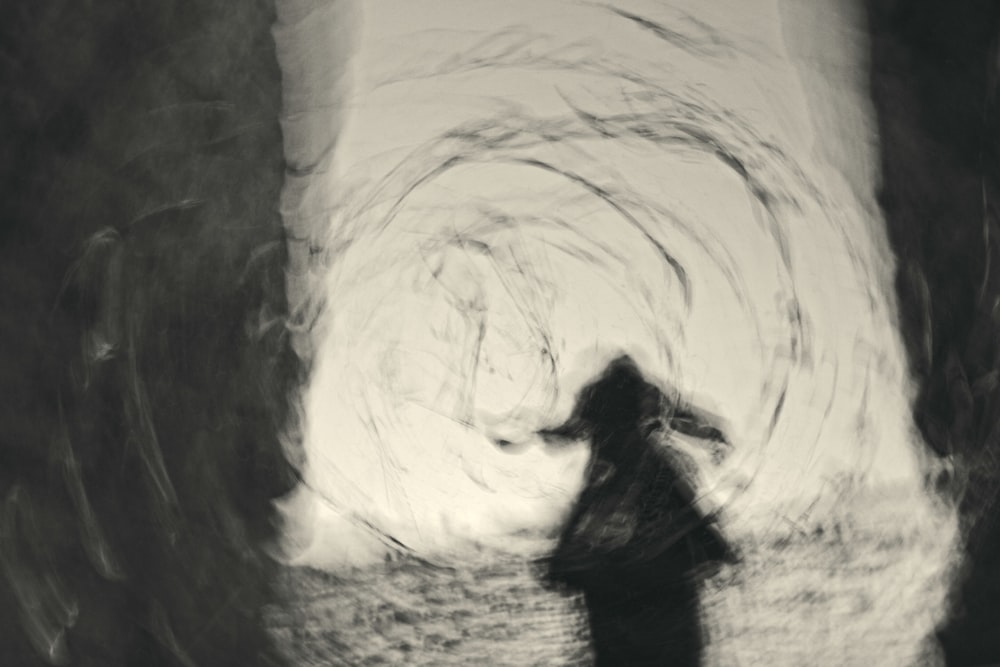 woman in black dress standing in front of white wall