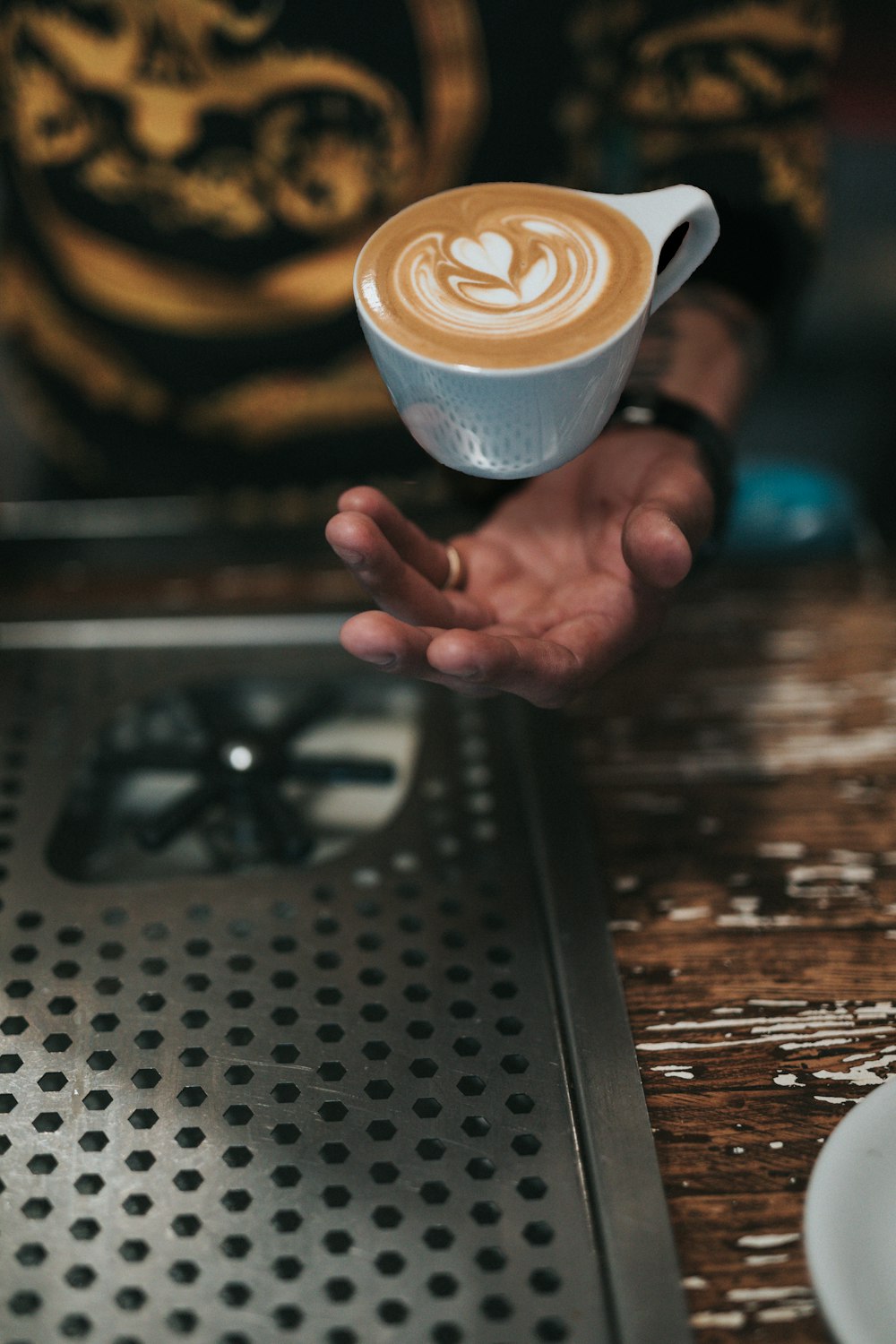 cup of cafe over person's hand